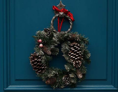 A Christmas wreath on a dark blue front door