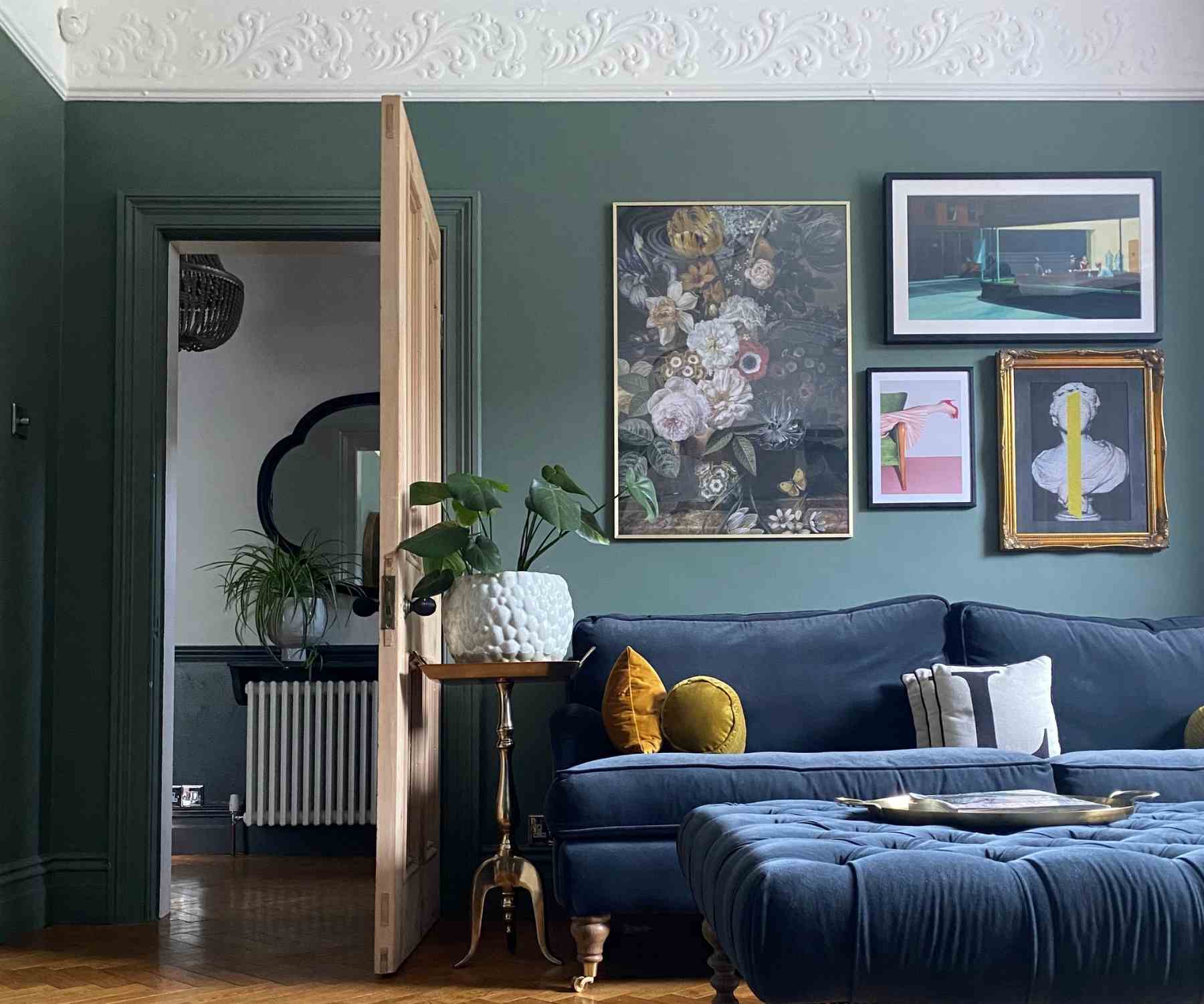 Living room with dark grey walls and deep blue velvet sofa