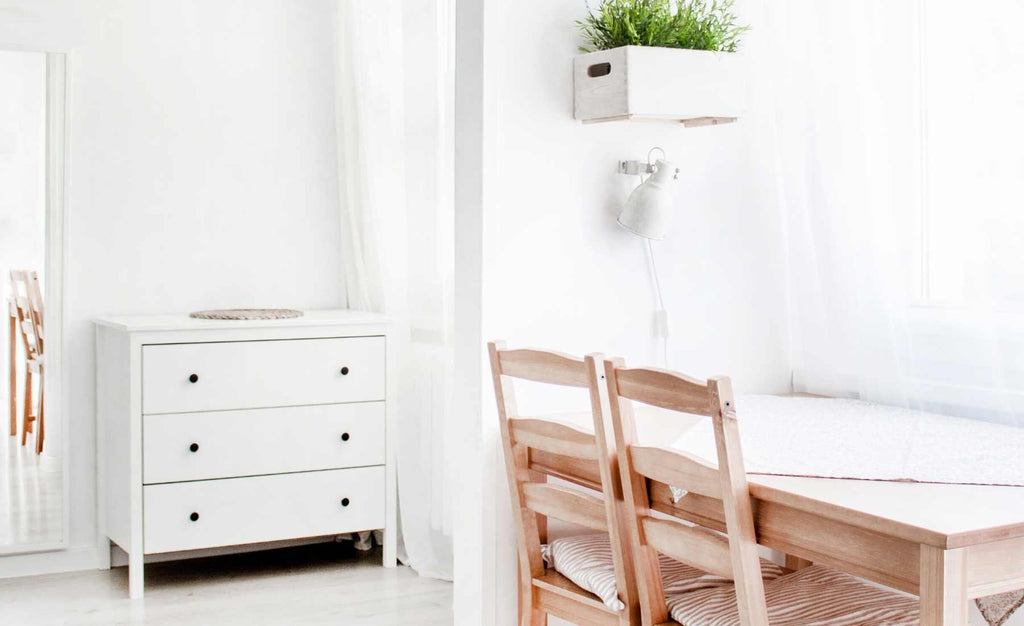 white desk with wooden chairs and white chest of drawers