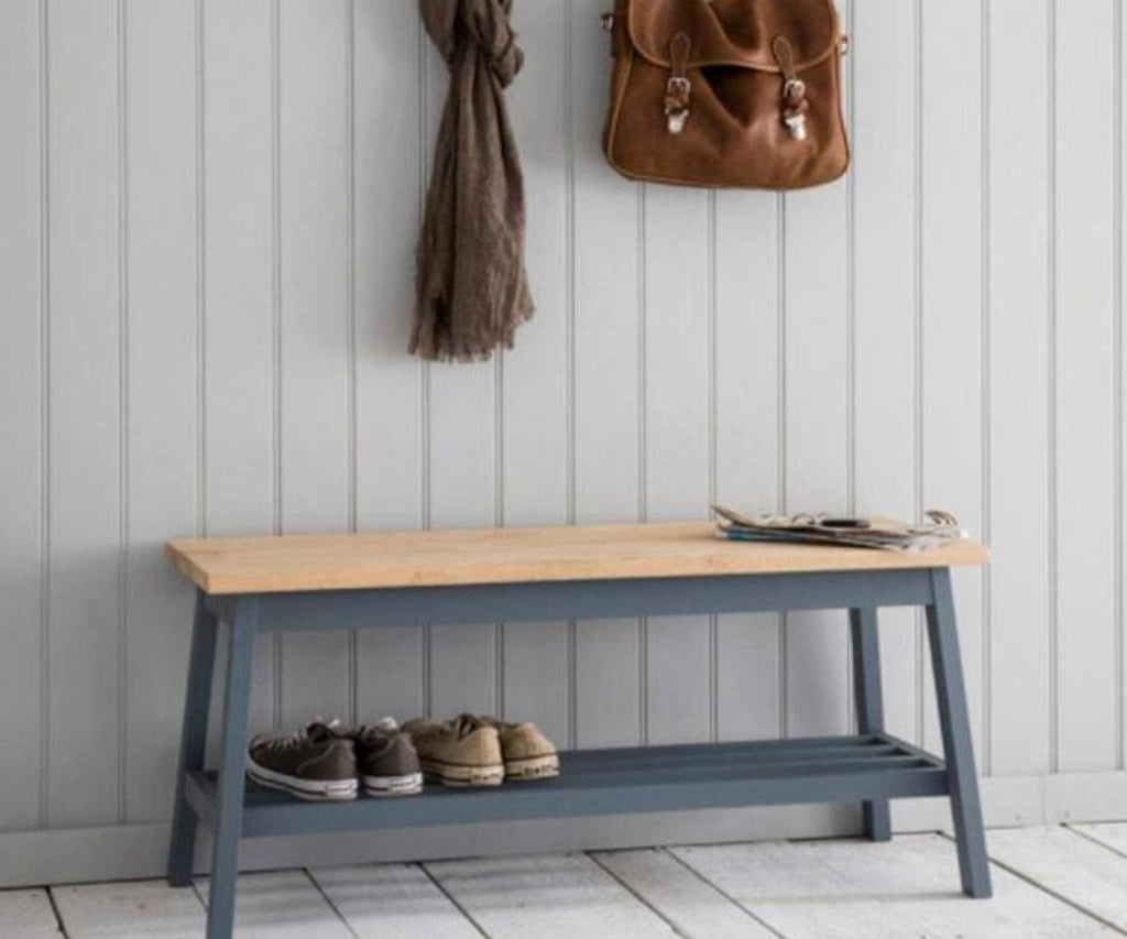 Wooden bench with blue legs against wood panelled wall