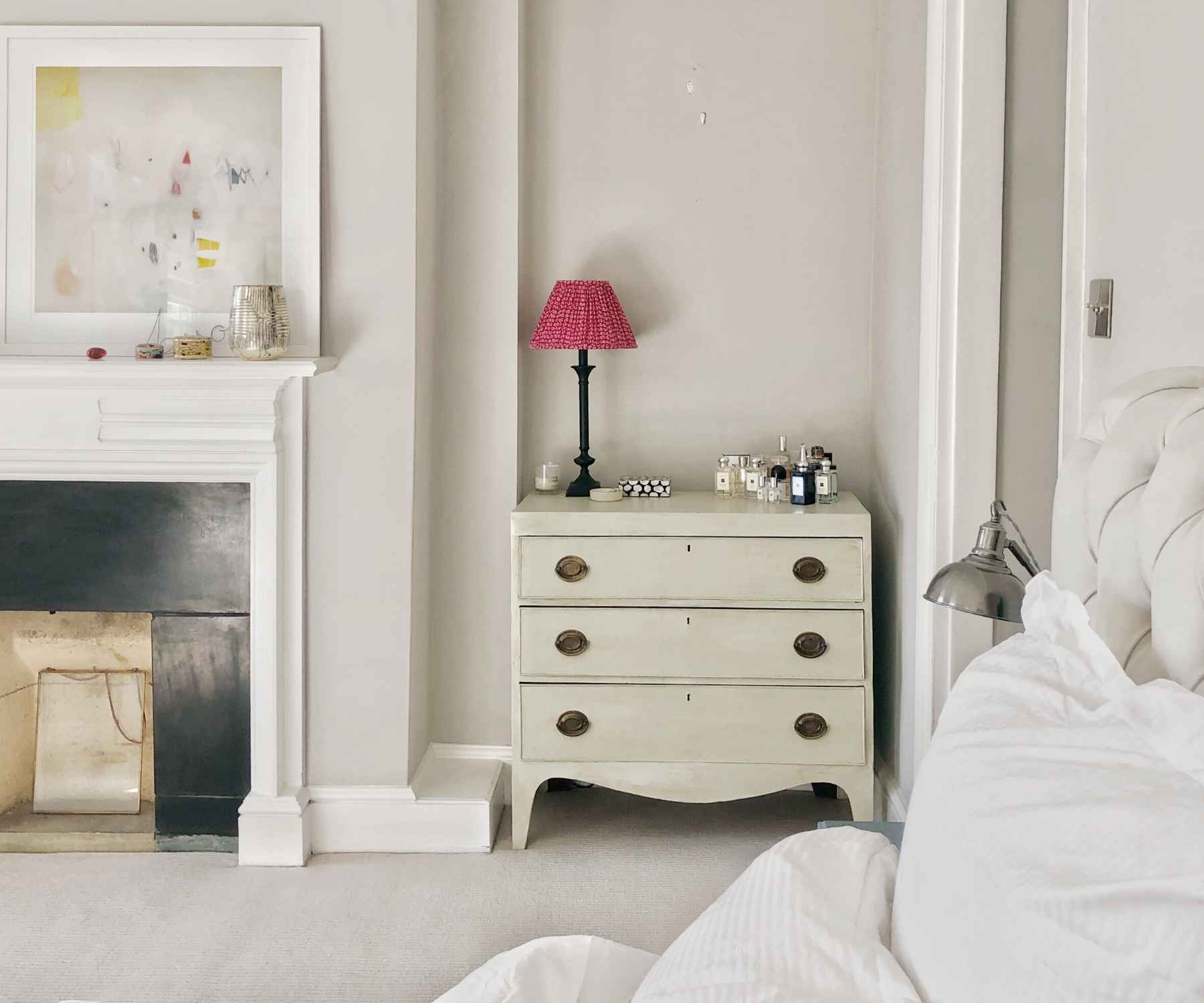 White bedroom chest of drawers with red lamp