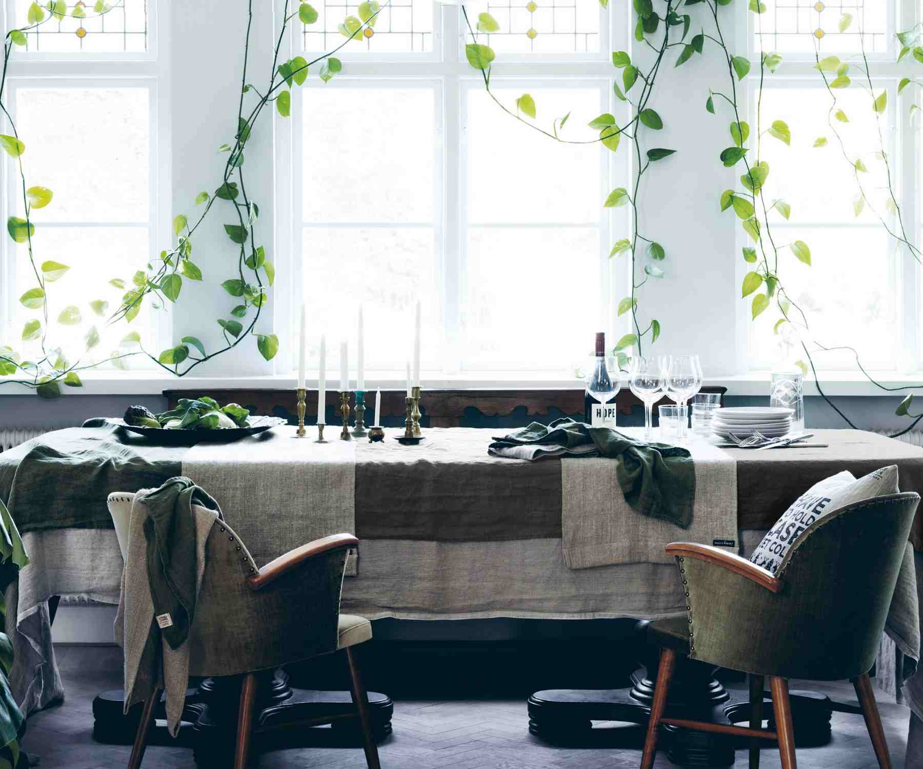 Large table with layered linen tablecloths in front of large window