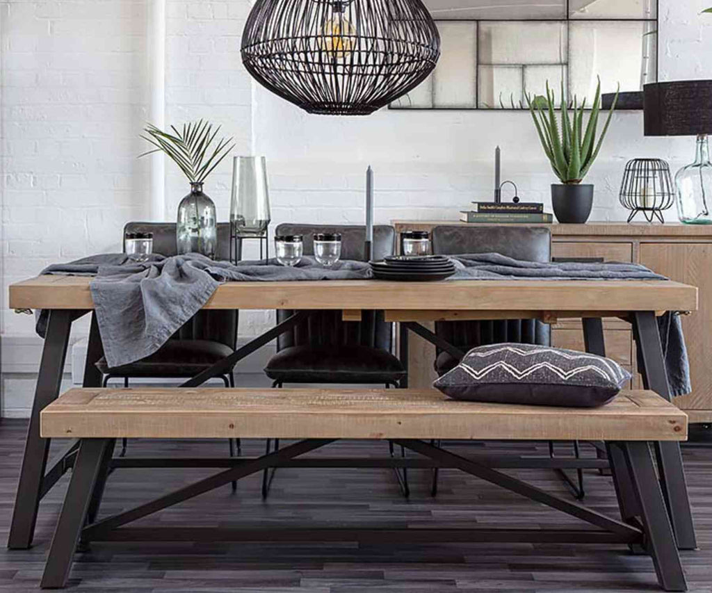 Industrial dining table with wooden bench and layered table linens