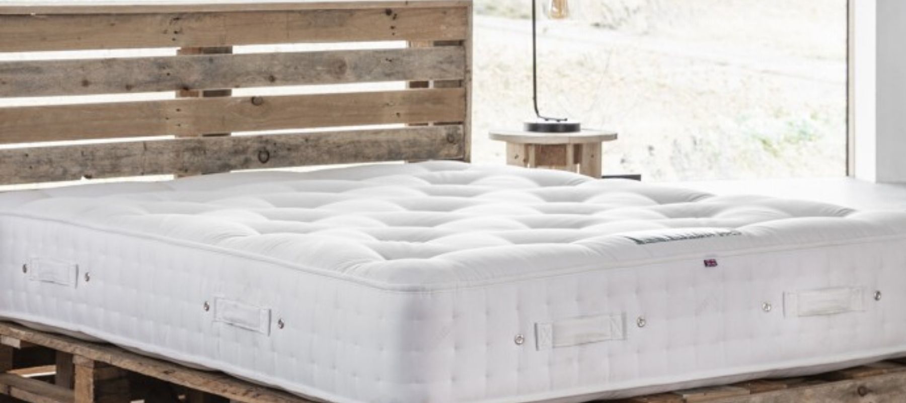 Wooden bed with large white mattress