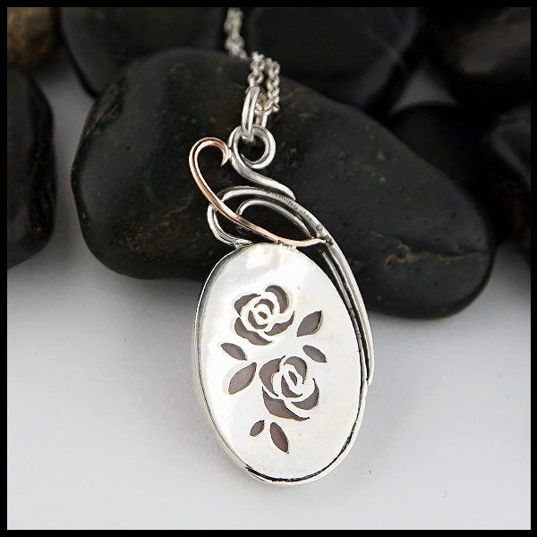 Rear view of custom Rose Quartz Floral Pendant. Hand-pierced Rose pattern in Sterling Silver visible on back of pendant.