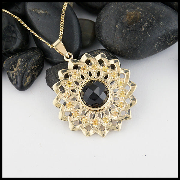 14K Yellow gold sunflower pendant set with 16 yellow sapphires and a center rose cut onyx on a 14K Yellow Gold Light Curb Chain.