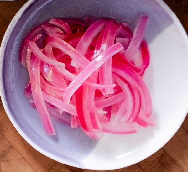 Pickled red onions on a small plate