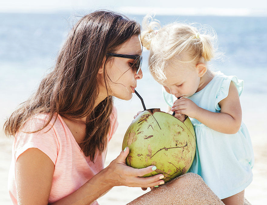 Mother and child sharing a coconut drink