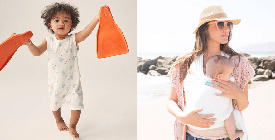 Mother on beach carrying baby in wrap and child with flippers