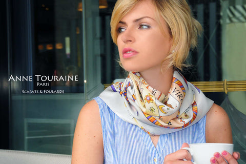 Astrology zodiac inspired silk scarf by ANNE TOURAINE Paris™; white color; tied around the neck over a pastel blue top
