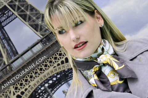 French stylish woman: neutral palette and elegant ANNE TOURAINE Paris™ silk scarf as a neck scarf over a classic trench coat 