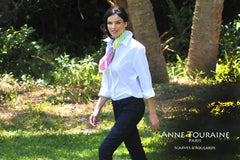 Rainbow scarf on a white blouse over a pair of jeans