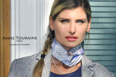 A stunning silk scarf tied close to the neck and combined with a pearl necklace: a true sign of Parisian elegance