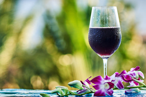 Chilled glass of red wine next to flowers