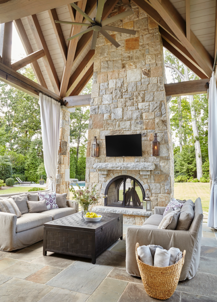 A soaring ceiling, a gorgeous fireplace and beautiful, comfortable furnishings make this the place to be for outdoor time. (<a href="http://www.traditionalhome.com/" target="_blank">Traditional Home</a>/Emily Followill)