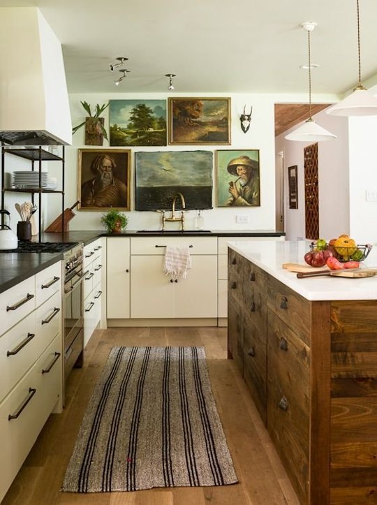 We love this image of art hung in the kitchen in a design by designer Lauren Lies