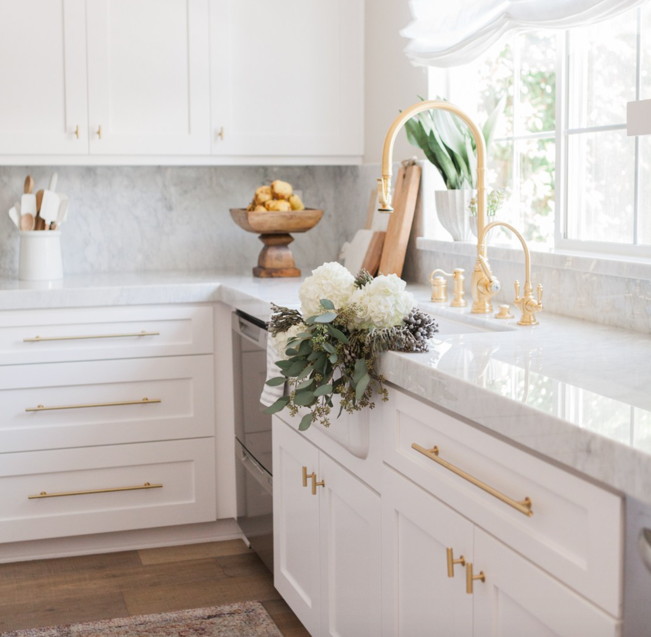 A pretty all-white kitchen with lust-worthy hardware.   From <a href="https://lemonstripes.com/decor/our-kitchen-before/" target="_blank">Lemonstripes</a> blog.