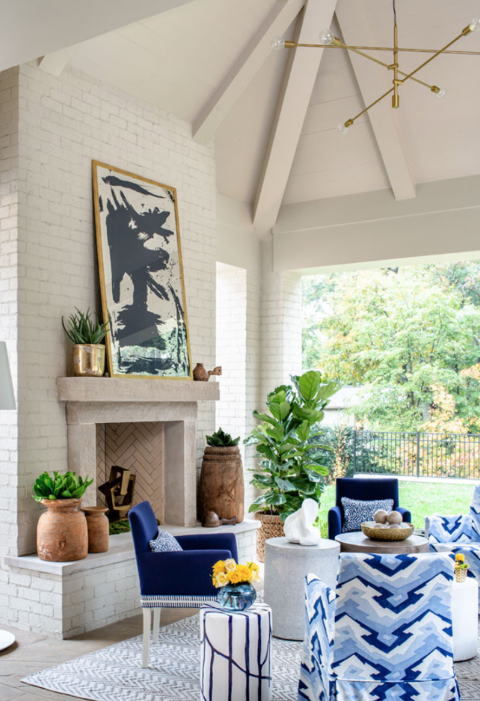 The porch, perfect for all-year lounging, gets its chic on with a geometrical chandelier, jazzy Thibaut upholstery and an original painting on mirror by Stacy Milburn. Design by <a href="http://kkongdesigns.com/index.html" target="_blank">Kristen Kong</a>.