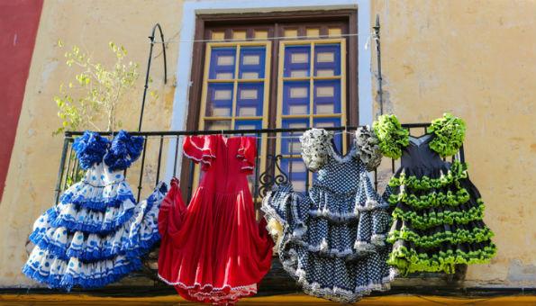 Típico balcón español con vestidos flamencos colgados de la baranda