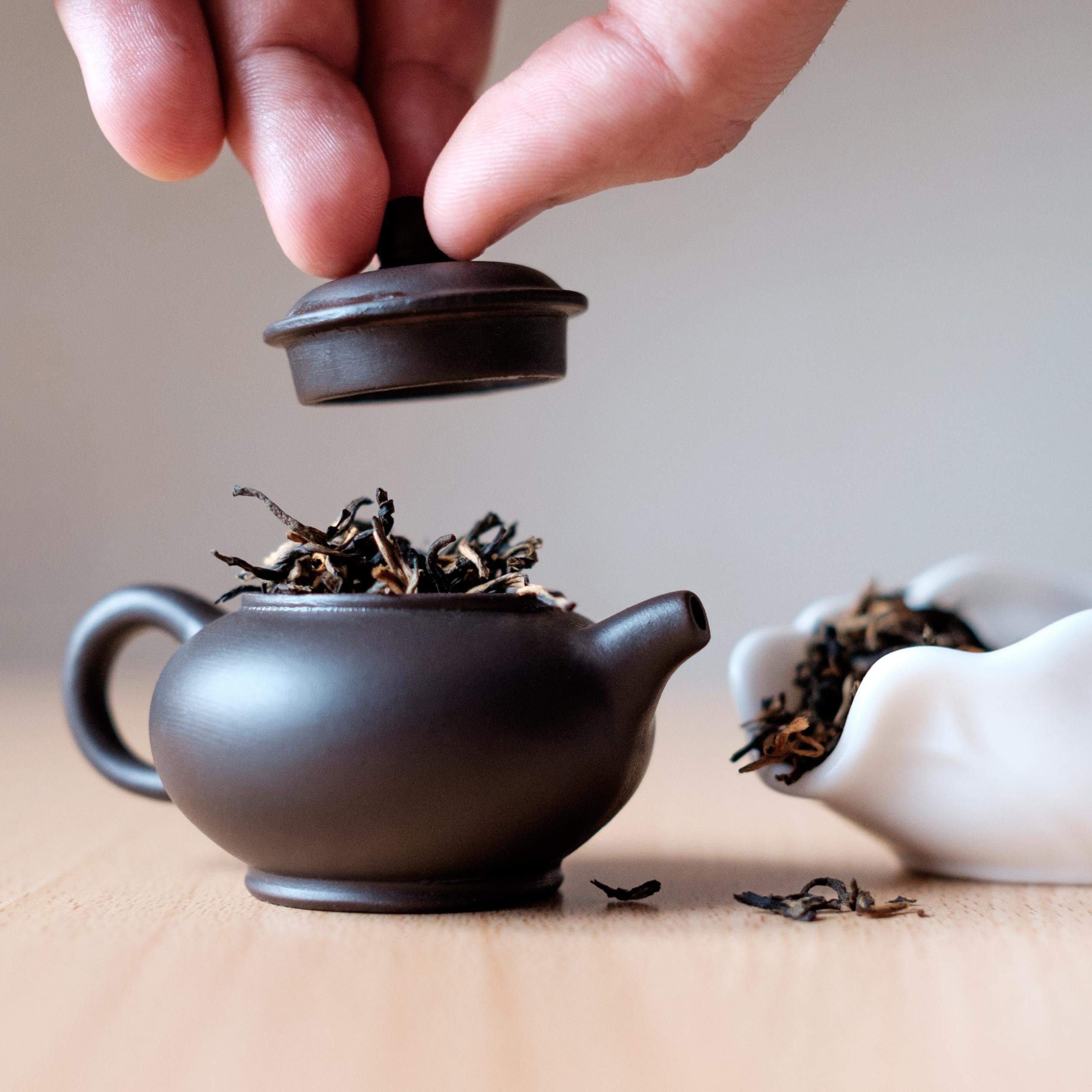 gongfu tea brewing with a small teapot and lots of leaves