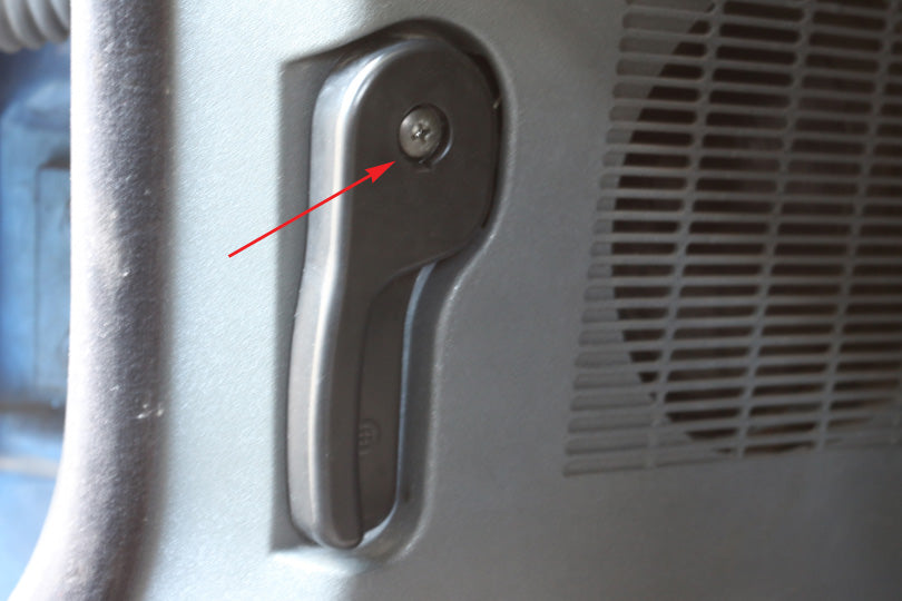 Screw to be removed from the hood release lever is indicated with an arrow.