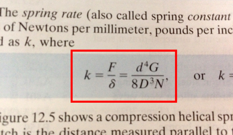 Excerpt from textbook showing an equation for coil spring calculations.
