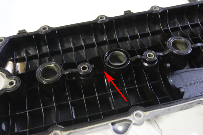 Underside of valve cover with missing pieces of gasket.