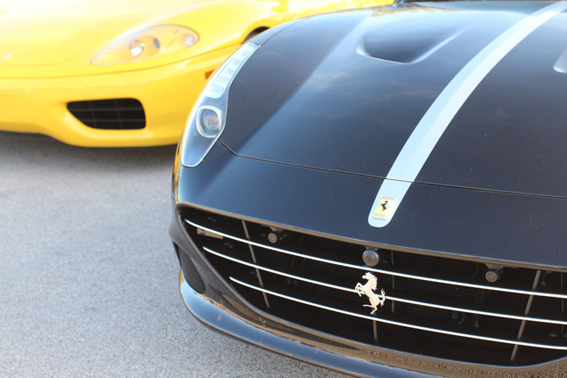 Black Ferrari in foreground and yellow Ferrari in background.