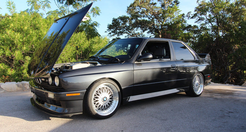 Black BMW E30 M3 with hood open.