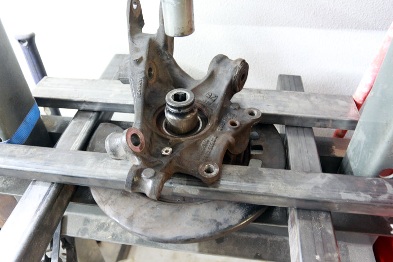 Wheel hub being pressed out with a shop press.