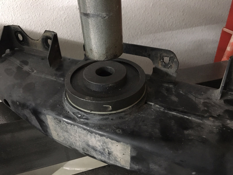 Transmission mount being pressed out by a shop press.