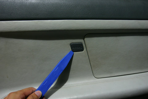 Airbag label being pried out with a nylon pry bar.