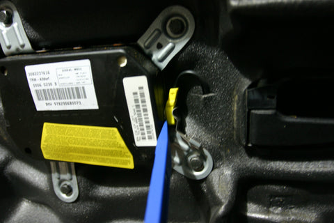 Removing the power connector to the airbag with a nylon pry bar.