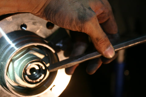 Chisel being used to make a holding notch in the axle nut.