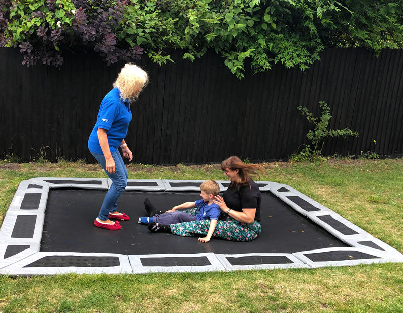 Child playing on in-ground trampoline