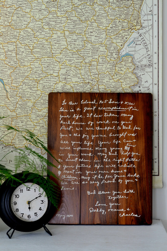 Handwriting memory sign on wood with map, clock and fern