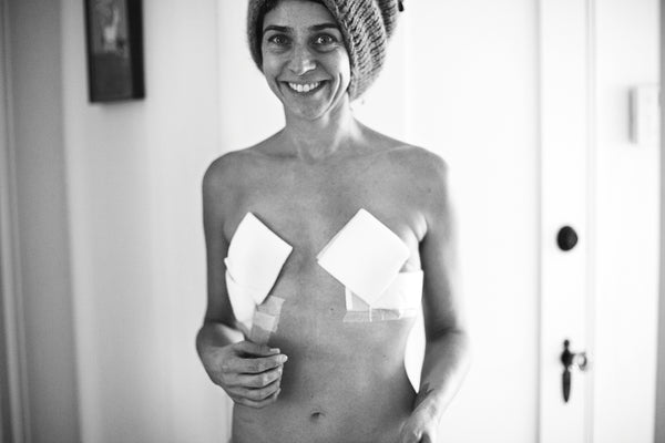 Samantha with tape and band aids over her breasts 