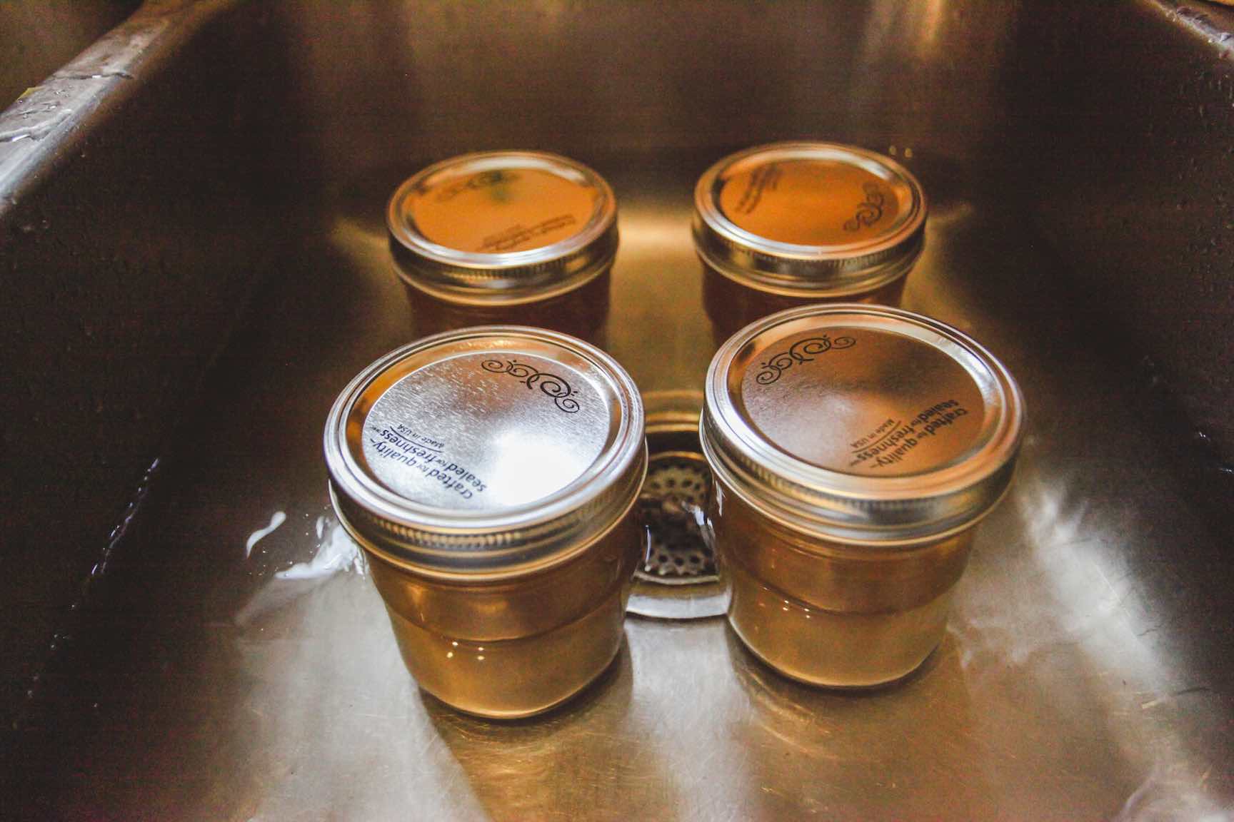cooling homemade bone broth in a water bath in canning jars