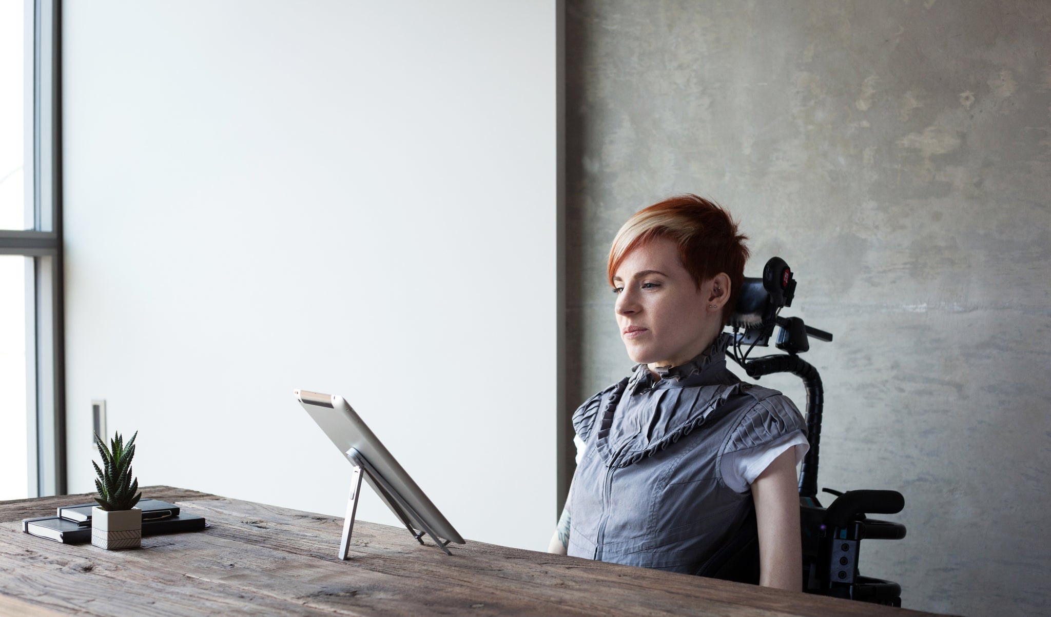 Carolyn using her iPad with a wheelchair head array