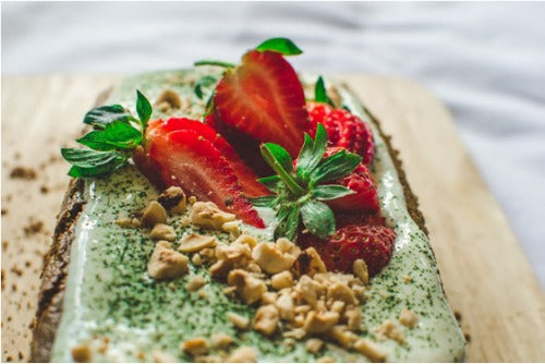 Green Tea Cake with vanilla frosting made with honey yogurt topped with fruits and nuts