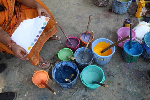 An Indian artisan mixes natural dyes in a variety of colors for Passion Lilie's clothing made in India.