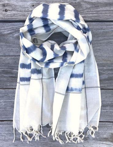 This Blue Striped Scarf from Passion Lilie features blue stripes on white handwoven fabric and tassels at the ends.