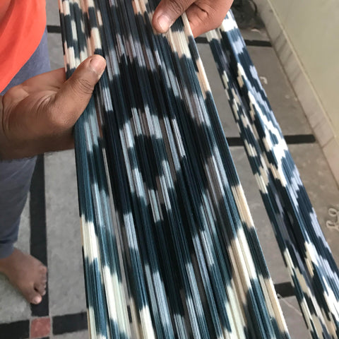 Ikat woven fabric from Passion Lilie, shown here in a white, blue, and turquoise diamond pattern and made with environmentally friendly dyes and materials.