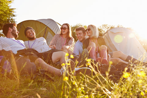 Young people hanging out by their tents, one of many items we recommend in our Festival Gear Guide.