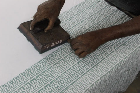 An artisan hand block printing fabric for Passion Lilie's clothes made in India.