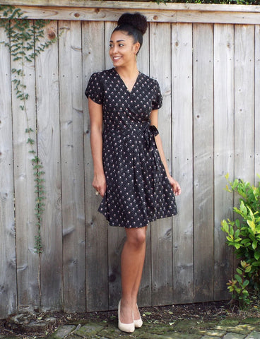Black with a subtle gray-and-peach poppies with polka dots design, this Fall Poppies Wrap Dress from Passion Lilie has short sleeves and pockets.