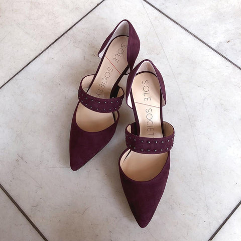 The Drisela is a pair of pointed toe pumps, shown here in a rich burgundy suede with silver metallic studs on the top strap.