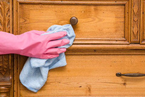 How Often Should I Vacuum My Dorm? cleaning with pink gloves and microfiber cloth