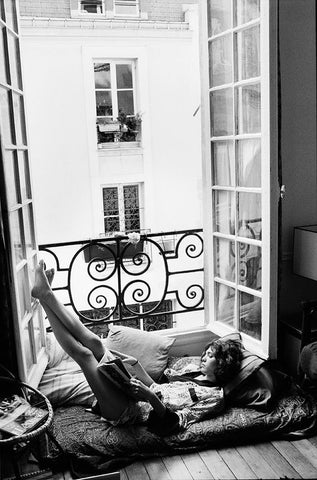 Black and White photography. Woman reading on balcony. Big open Windows