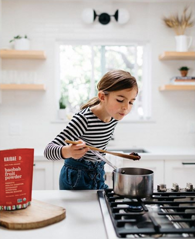 Healthy young girl makes kaibae baobab quick jam recipe on the stove